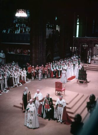 Couronnement de la reine Elizabeth II à l’abbaye de Westminster, Londres, le 2 juin 1953. Cette image montre la cérémonie où la reine prête serment et reçoit la couronne, entourée de dignitaires et de membres de la famille royale. © Bibliothèque et Archives Canada, K-0000045, sous licence Creative Commons Attribution 2.0.