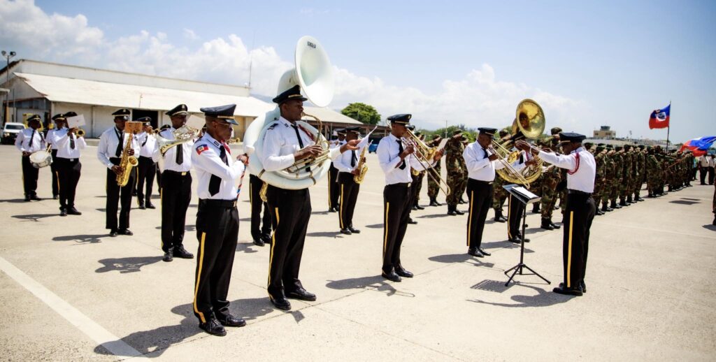 La fanfare de la Police nationale d’Haïti joue en l’honneur de la visite officielle du président Gustavo Petro, à l’aéroport international Toussaint Louverture, le 18 juillet 2025. Photo credit : Présidence / Haïti.