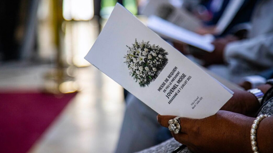Une personne tient le programme d’une messe de requiem en mémoire de l’ancien président Jovenel Moïse lors d’une cérémonie organisée le 7 juillet 2026 à la Villa d’Accueil, à Port-au-Prince, cinq ans après son assassinat. Photo : Présidence d’Haïti/Facebook.