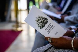 Une personne tient le programme d’une messe de requiem en mémoire de l’ancien président Jovenel Moïse lors d’une cérémonie organisée le 7 juillet 2026 à la Villa d’Accueil, à Port-au-Prince, cinq ans après son assassinat. Photo : Présidence d’Haïti/Facebook.